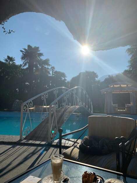 Swimming pool by sea against sky on sunny day