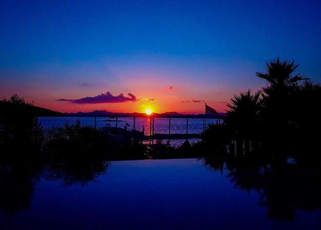 Swimming pool by sea at sunset