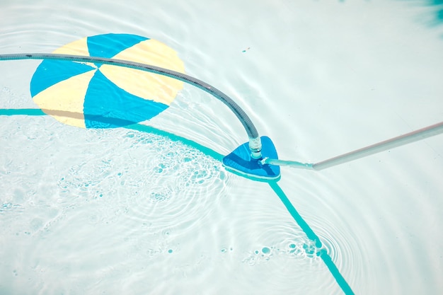 Swimming pool cleaning tools in the bottom of the pool. Clear water in the pool.