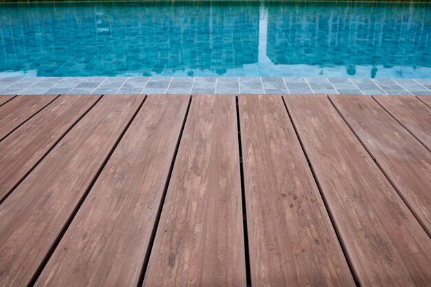 Swimming pool deck wood floor and blue water background selective focus