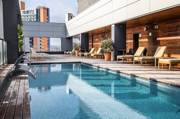 Photo swimming pool on roof top with beautiful city view of the skyscrapers. . premium hotel. 03.01.2020 barcelona, spain