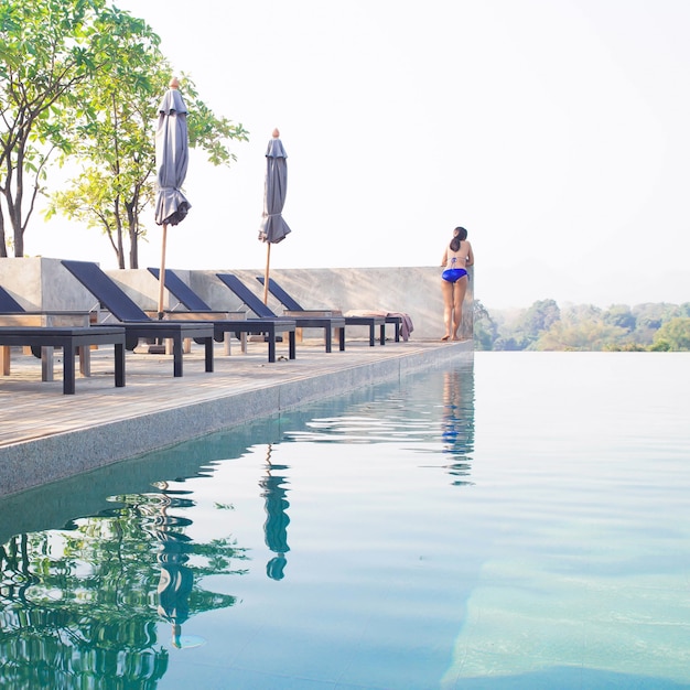 Swimming pool on the roof top with bikini female. Summer travel concept