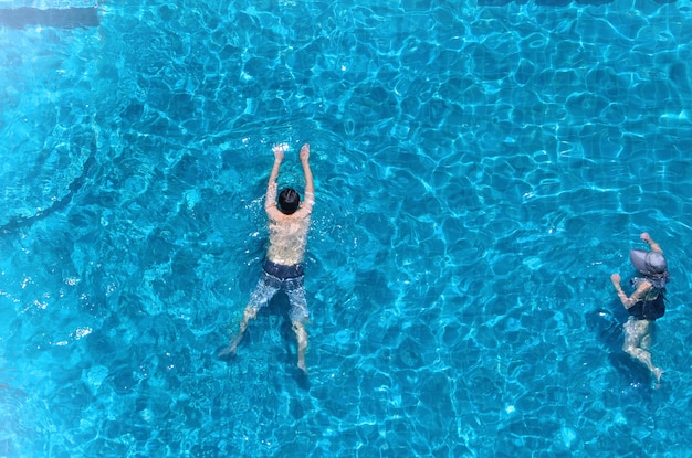 Swimming pool top view angle which blue color clear water and sun light reflect on surface texture