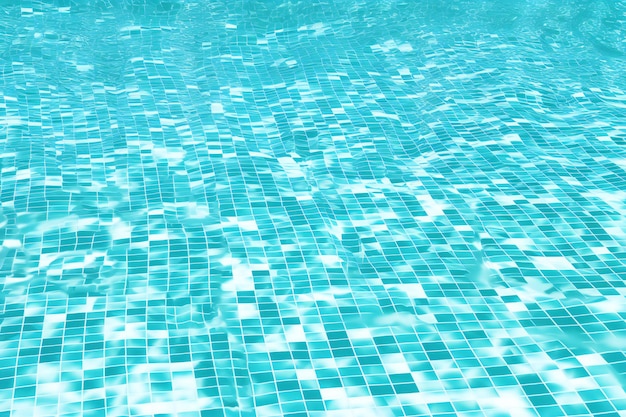 Swimming pool water with sun reflections blue mosaic tile background