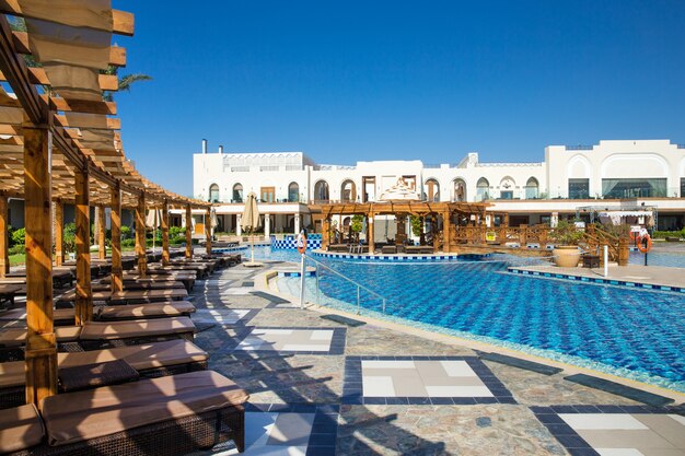 Swimming pool with coconut tree and white umbrella