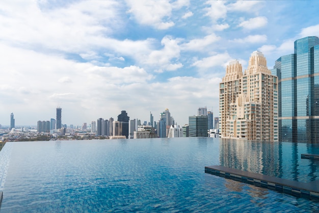 Swimming pool with modern building in business city center and blue sky in sunny day.