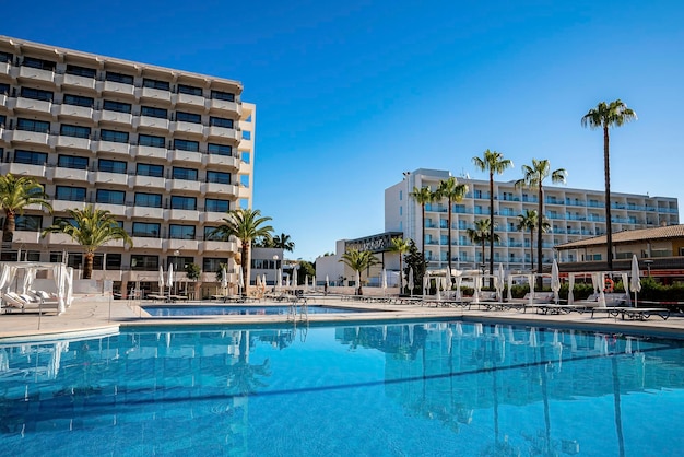 Swimming pool with view of trees and luxurious hotels against clear blue sky