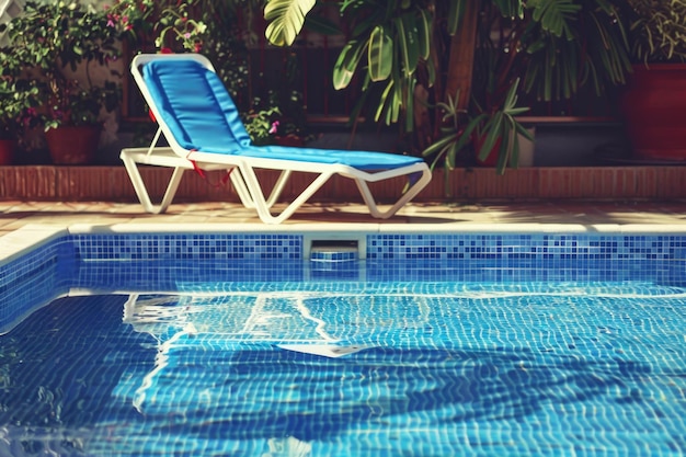 Foto piscine rilassamento con blue chaise longue accanto alla piscina in giardino