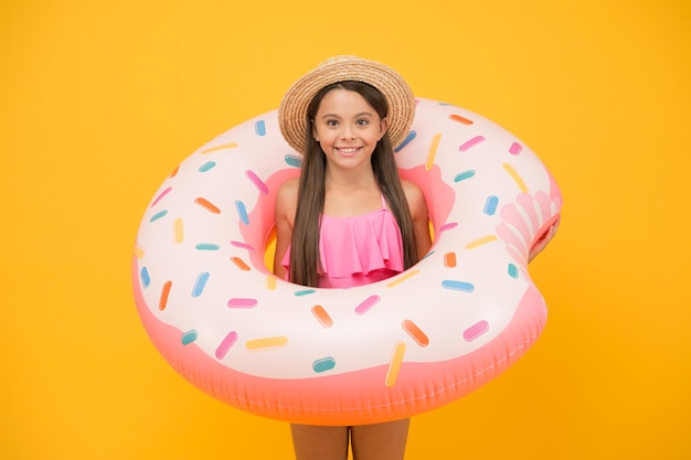 Swimming and sunbathing Summer vacation Rest at seaside Pool party Happy childhood Entertainment concept Little girl and swimming donut ring Kid in swimsuit having fun water activities