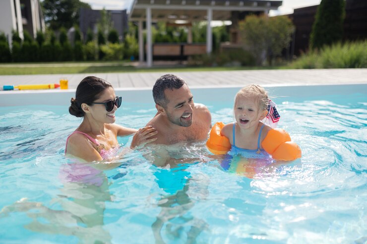Photo swimming with parents. cute blonde girl feeling excited and amazing while swimming with parents