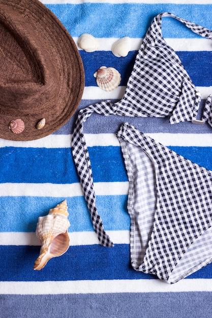 Swimsuit with beach accessories on blue background