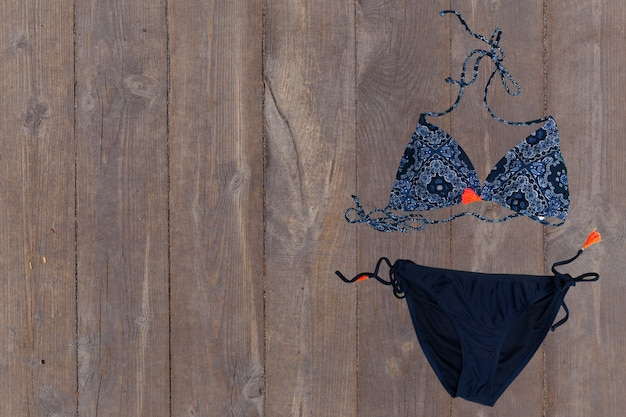 Swimsuit on wooden background. top view