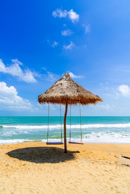 Swing on beach with ocean sea and blue sky