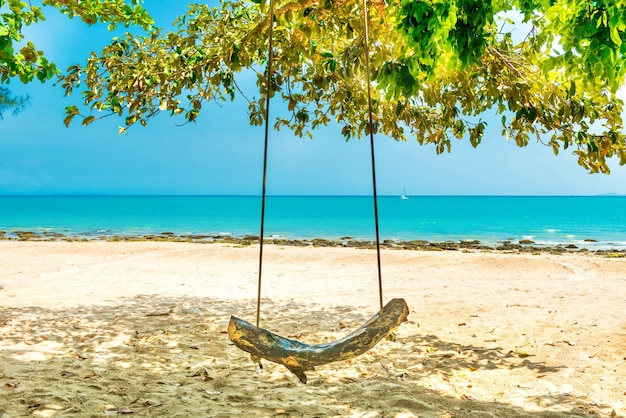 Foto oscillare sulla spiaggia di sabbia all'isola tropicale