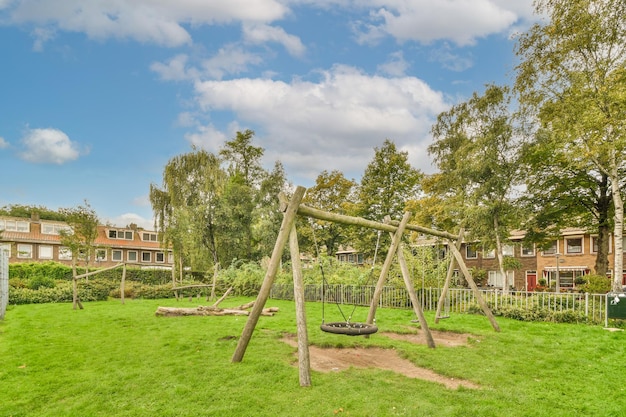 A swing set in a park with trees and houses