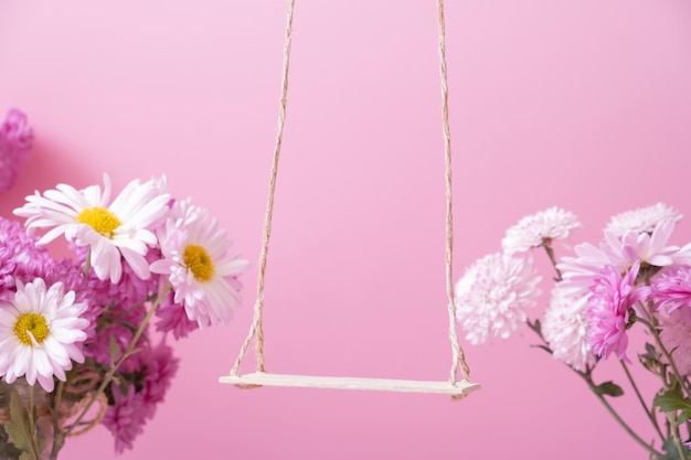 Качели с цветами хризантем как подставка для вашего косметического средства Креативный подиум или пьедестал