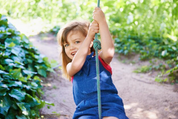 Swinging away shot of an adorable little girl swinging on a rope