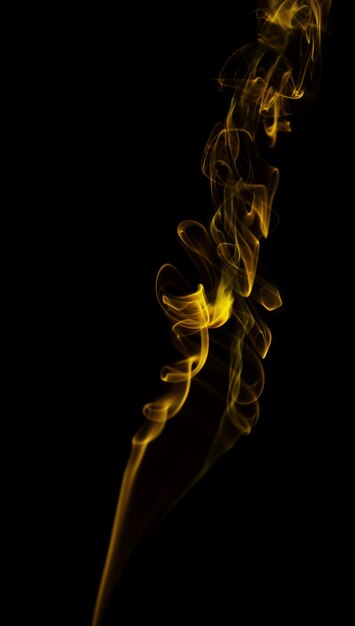 Swirl of yellow smoke on black background