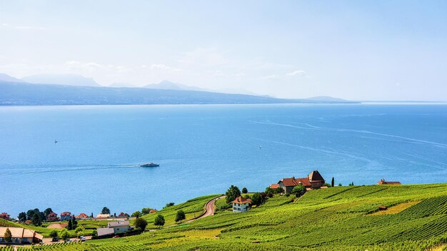 Swiss Houses at Lavaux Vineyard Terraces hiking trail and ship on Lake Geneva and Swiss mountains, Lavaux-Oron district of Switzerland