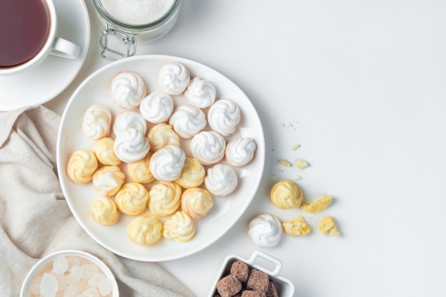 Swiss meringues in a plate on a light background. The concept of the desserts.