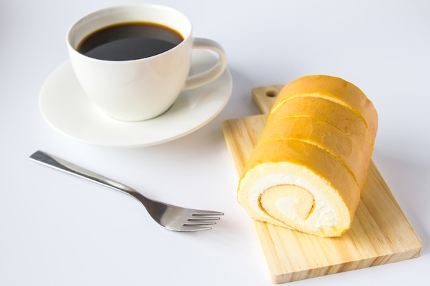 Swiss roll en koffie op witte achtergrond.