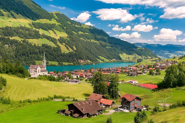 Obwalden Switzerland의 Lungerersee 호수를 따라 전통 가옥과 NeoGothic 교회가 있는 스위스 마을 Lungern