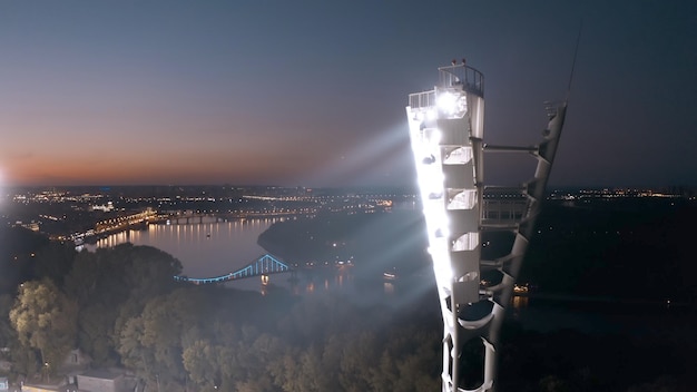 Photo switching on the light tower of a football stadium against a sunset and a night city cinematic