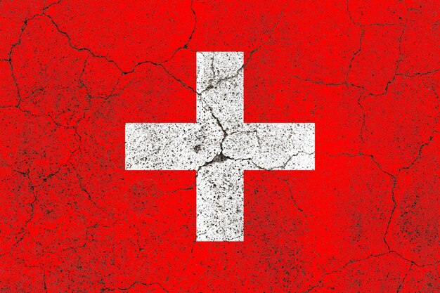 Switzerland flag on a cracked old concrete wall surface