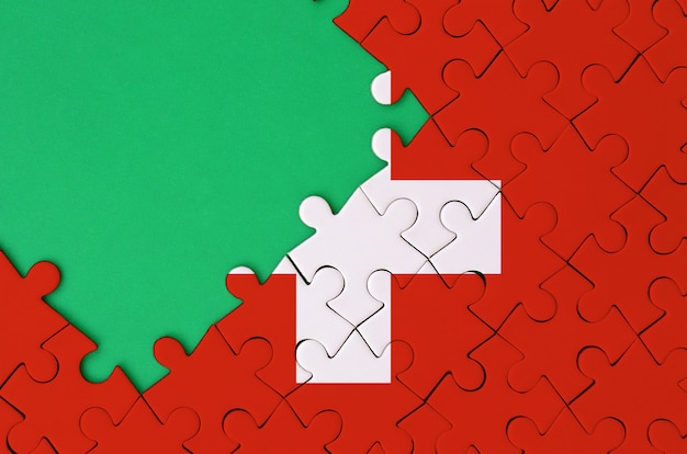 Switzerland flag  is depicted on a completed jigsaw puzzle with free green copy space on the left side