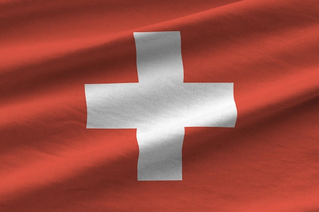 Switzerland flag with big folds waving close up under the studio light indoors The official symbols and colors in banner