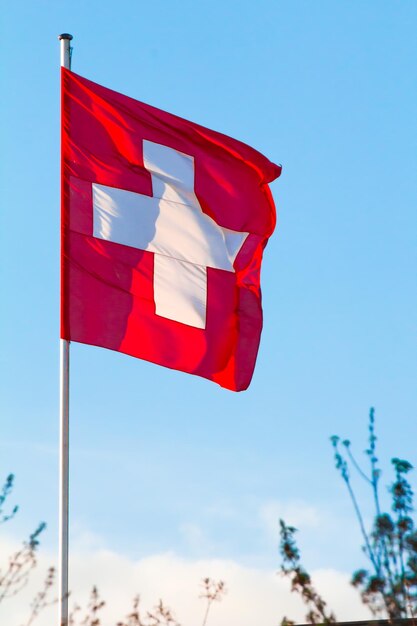 Switzerland national flag waving on blue sky background swiss confederation ch