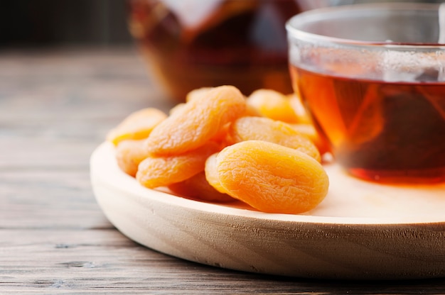 Swwet dried apricots with cup of black tea