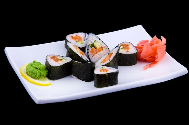 Syake ikura maki - sushi roll con salmone fresco e cetriolo all'interno su piatto rettangolare bianco.