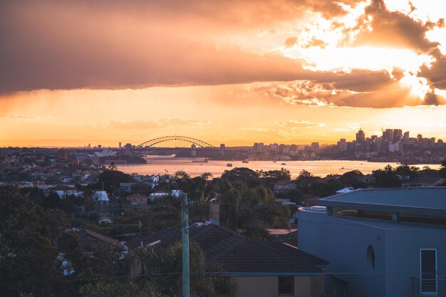 Foto ponte del porto di sydney sul fiume in città durante il tramonto