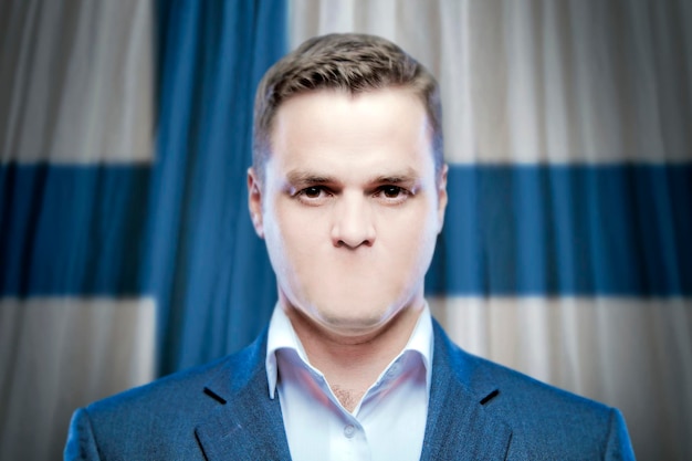 Symbol of censorship and freedom of speech a young man without a mouth on a background of the national flag of Finland