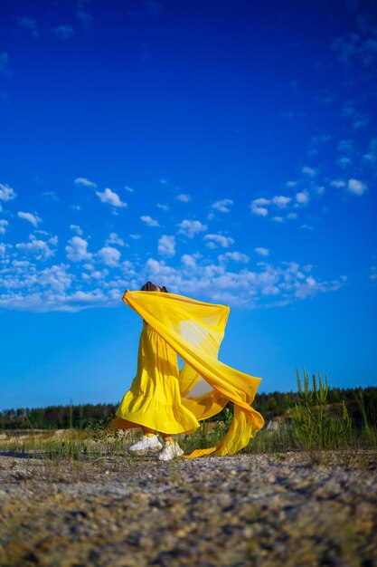 The symbol of freedom is a ukrainian girl of 7 years old\
patriotically dressed in a yellow dress against a blue sky blue sky\
sunny day free ukrainian child child symbol of ukraine