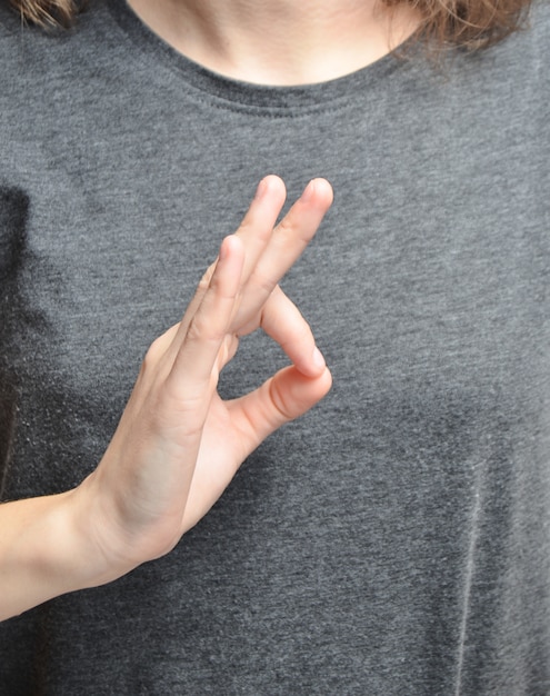 The symbol "okay" from the fingers of a woman's hand. The symbol of equilibrium.