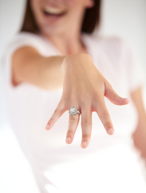 Symbolen van levenslange liefde Bijgesneden opname van de hand van een vrouw met een verlovingsring