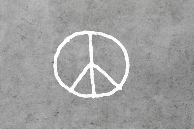 symbolic, pacifism and hippie concept - peace sign drawing on gray concrete wall