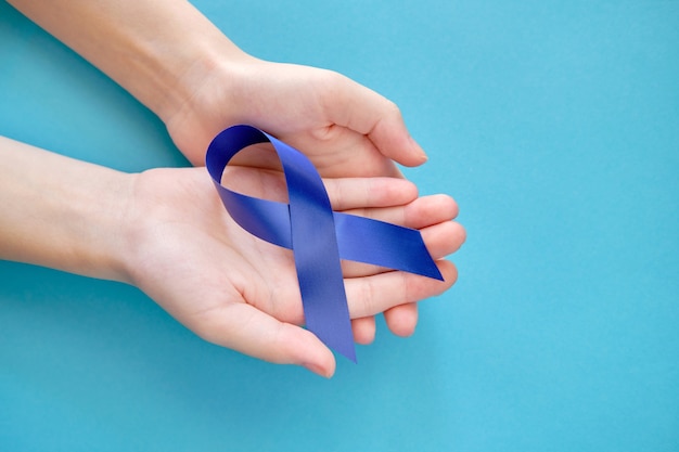 symbolic ribbon on woman's hands over a white surface