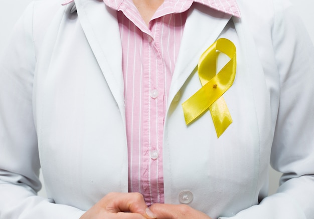 A symbolic yellow ribbon on the chest of a doctor.