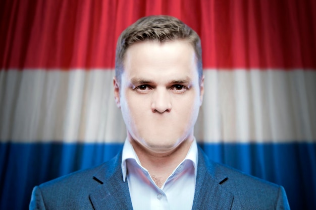 Symbool van censuur en vrijheid van meningsuiting een jonge man zonder mond op een achtergrond van de nationale vlag van Nederland