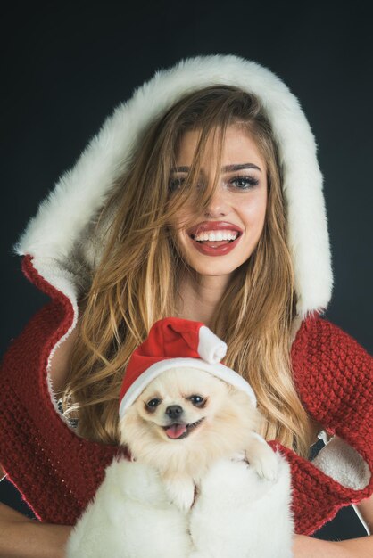 Symbool van kerstmis en nieuwjaar gelukkig santa meisje en hond bij kerstmis vrouw en hond in santa hat