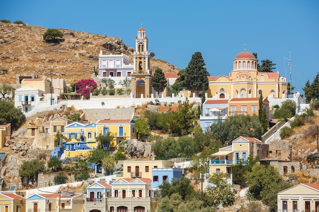 SYMI GRIEKENLAND September 62015 Uitzicht op een kuststraat en vissersboten afgemeerd in de haven van Yialos op het eiland Symi, Griekenland Symi is een gemakkelijke en meest populaire bestemming voor dagtochten vanaf het eiland Rhodos