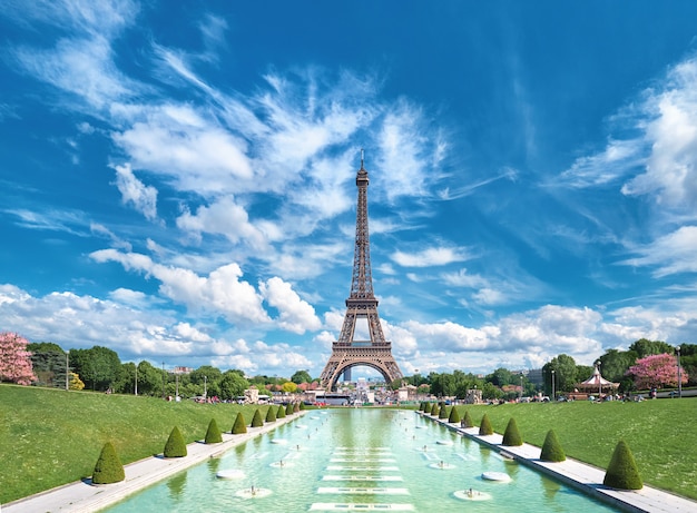 Trocadero의 분수에서 찍은 밝고 화창한 오후에 에펠 탑의 대칭 전면 파노라마보기.