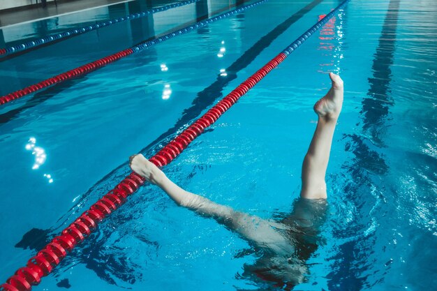 Atleta di nuoto sincronizzato si allena da solo in piscina