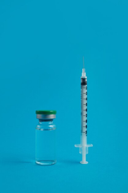 Syringe ampoule with medicine on blue background