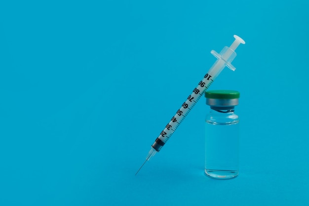 Syringe ampoule with medicine on blue background