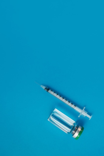 Syringe ampoule with medicine on blue background