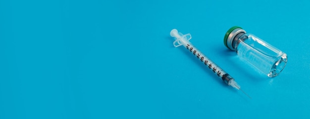 Syringe ampoule with medicine on blue panorama background